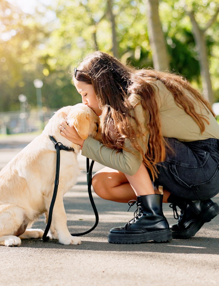 Una ragazza abbraccia il suo cane al parco