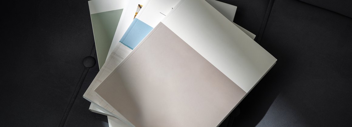 Brochure e campioni di carta appoggiati su un tavolo